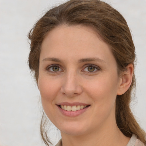 Joyful white young-adult female with long  brown hair and grey eyes