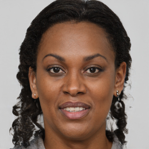 Joyful black adult female with medium  brown hair and brown eyes