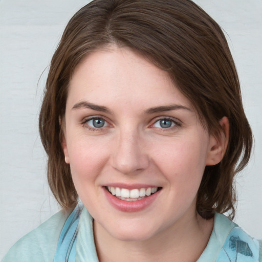 Joyful white young-adult female with medium  brown hair and blue eyes