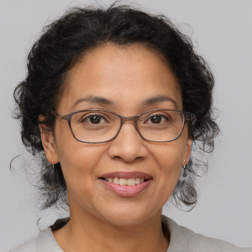 Joyful latino adult female with medium  brown hair and brown eyes