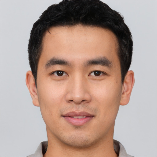 Joyful asian young-adult male with short  black hair and brown eyes