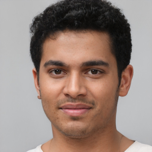 Joyful latino young-adult male with short  black hair and brown eyes