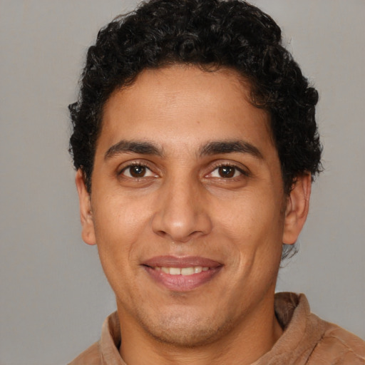 Joyful latino young-adult male with short  brown hair and brown eyes