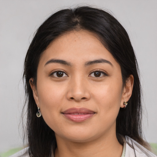 Joyful latino young-adult female with medium  brown hair and brown eyes