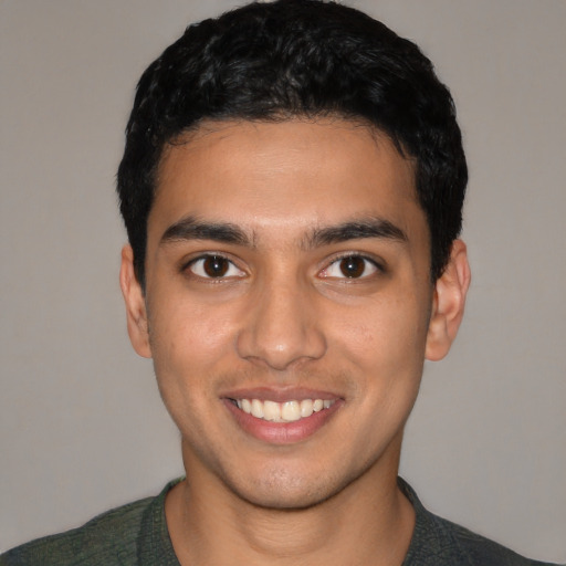 Joyful latino young-adult male with short  black hair and brown eyes