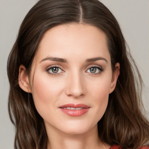 Joyful white young-adult female with long  brown hair and grey eyes