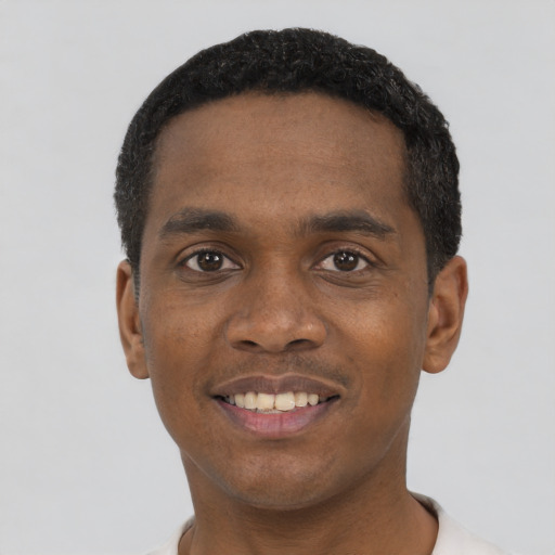 Joyful black young-adult male with short  black hair and brown eyes
