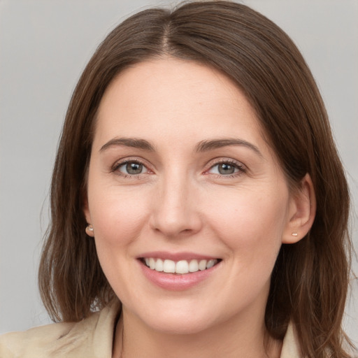 Joyful white young-adult female with medium  brown hair and grey eyes