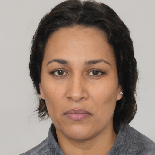 Neutral latino adult female with medium  brown hair and brown eyes
