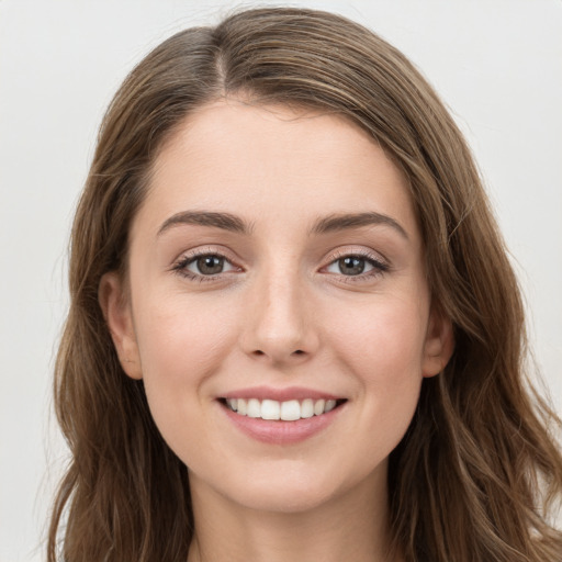 Joyful white young-adult female with long  brown hair and green eyes