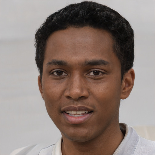 Joyful black young-adult male with short  black hair and brown eyes