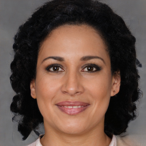 Joyful latino adult female with medium  brown hair and brown eyes