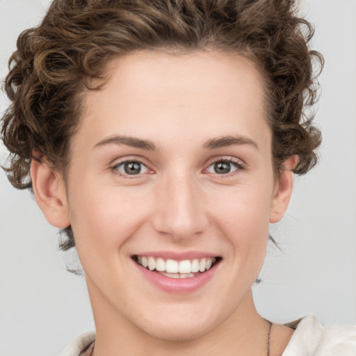 Joyful white young-adult female with short  brown hair and green eyes