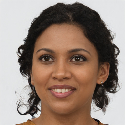 Joyful black young-adult female with long  brown hair and brown eyes