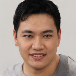 Joyful asian young-adult male with short  black hair and brown eyes