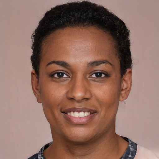 Joyful black young-adult female with short  black hair and brown eyes