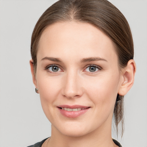 Joyful white young-adult female with medium  brown hair and grey eyes