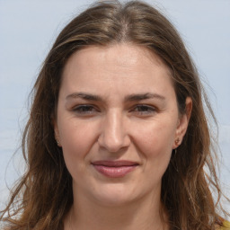 Joyful white adult female with long  brown hair and brown eyes