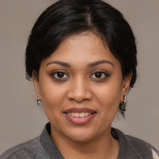 Joyful black young-adult female with short  black hair and brown eyes