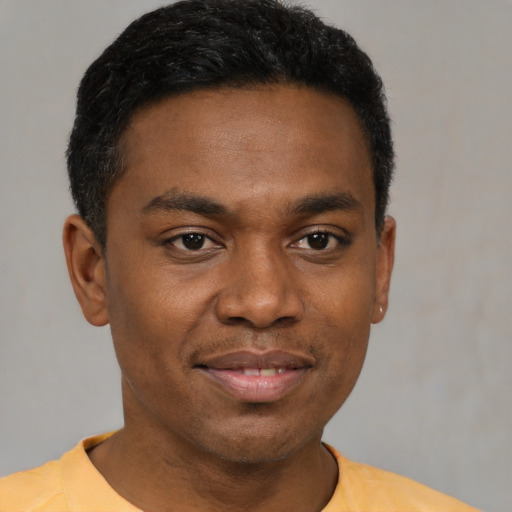 Joyful black young-adult male with short  black hair and brown eyes