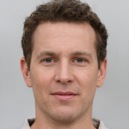 Joyful white adult male with short  brown hair and grey eyes