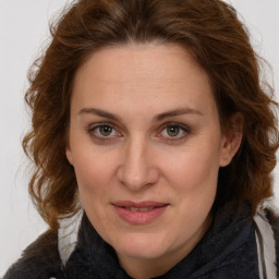 Joyful white adult female with medium  brown hair and green eyes