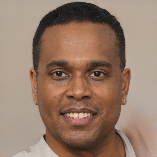 Joyful black adult male with short  black hair and brown eyes