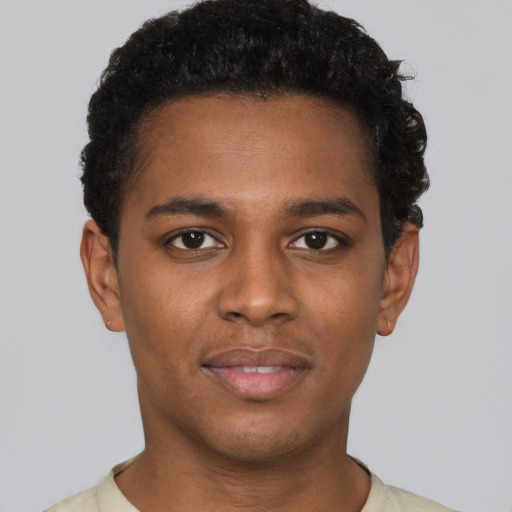 Joyful black young-adult male with short  brown hair and brown eyes