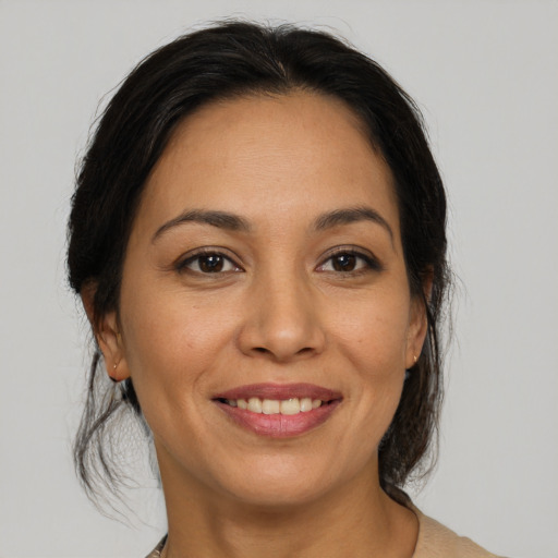 Joyful latino adult female with medium  brown hair and brown eyes