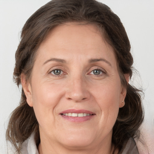 Joyful white adult female with medium  brown hair and grey eyes