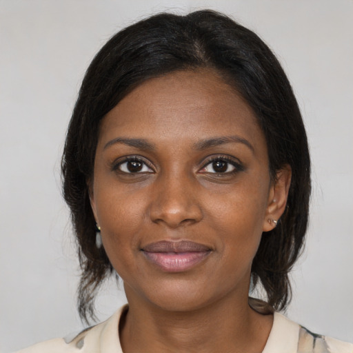 Joyful black young-adult female with medium  brown hair and brown eyes