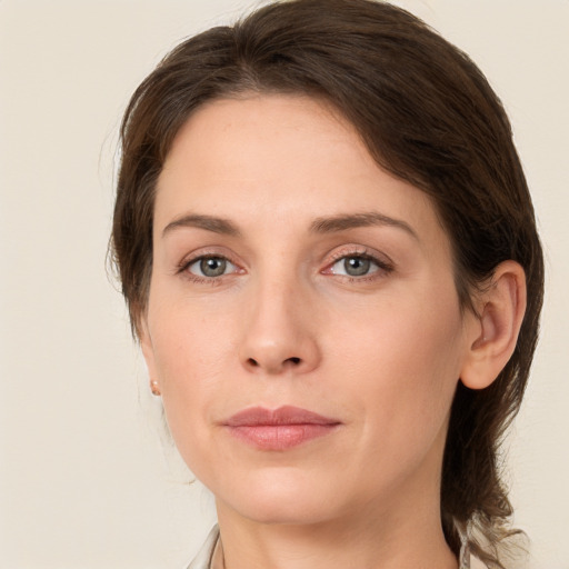 Joyful white young-adult female with medium  brown hair and grey eyes