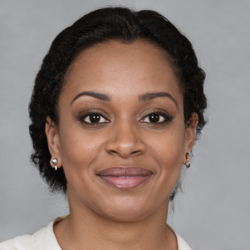 Joyful black adult female with short  brown hair and brown eyes