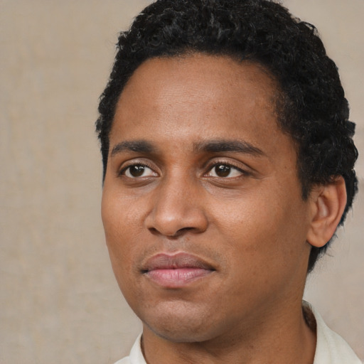 Joyful black young-adult male with short  black hair and brown eyes