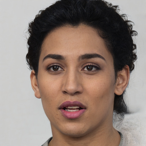 Joyful latino young-adult female with short  black hair and brown eyes