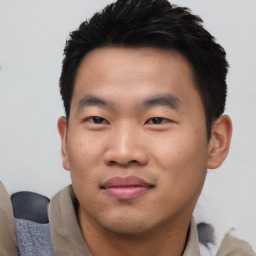 Joyful asian young-adult male with short  black hair and brown eyes