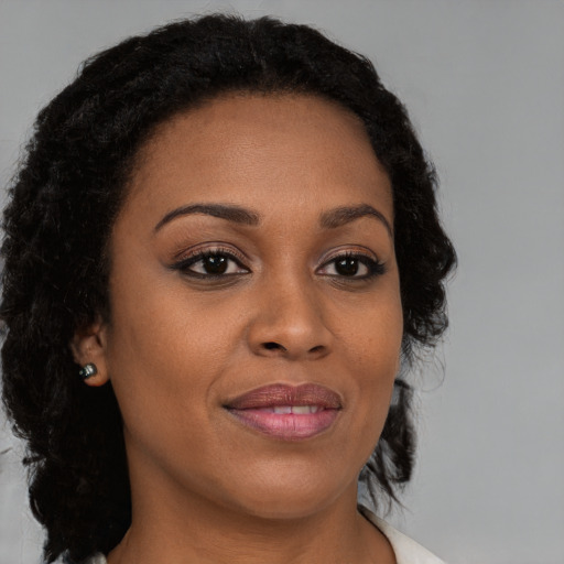 Joyful black young-adult female with medium  brown hair and brown eyes