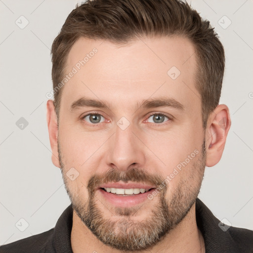 Joyful white young-adult male with short  brown hair and grey eyes