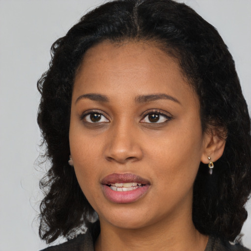 Joyful black young-adult female with long  brown hair and brown eyes