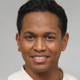 Joyful black young-adult male with short  black hair and brown eyes