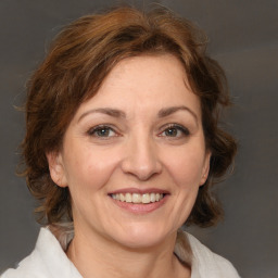 Joyful white adult female with medium  brown hair and grey eyes