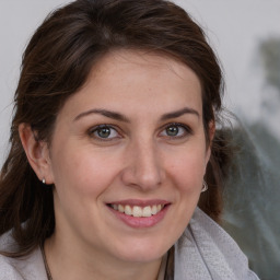 Joyful white adult female with medium  brown hair and brown eyes