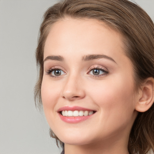 Joyful white young-adult female with long  brown hair and blue eyes