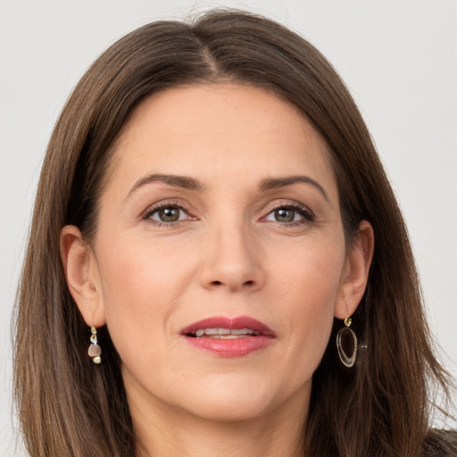 Joyful white adult female with long  brown hair and grey eyes