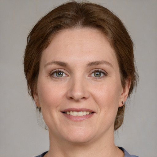 Joyful white adult female with medium  brown hair and green eyes