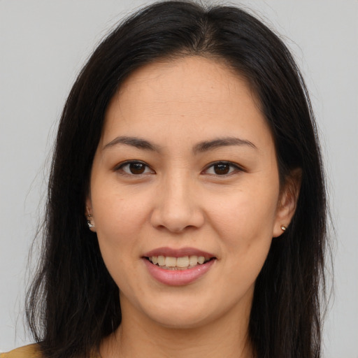 Joyful latino young-adult female with long  brown hair and brown eyes