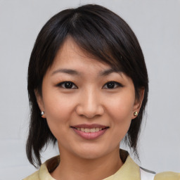 Joyful asian young-adult female with medium  brown hair and brown eyes