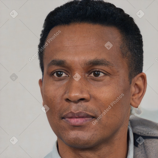 Joyful black adult male with short  black hair and brown eyes
