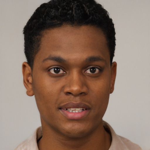 Joyful black young-adult male with short  brown hair and brown eyes