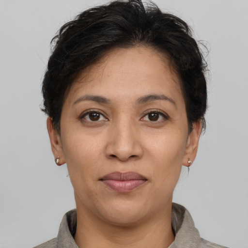 Joyful latino adult female with short  brown hair and brown eyes